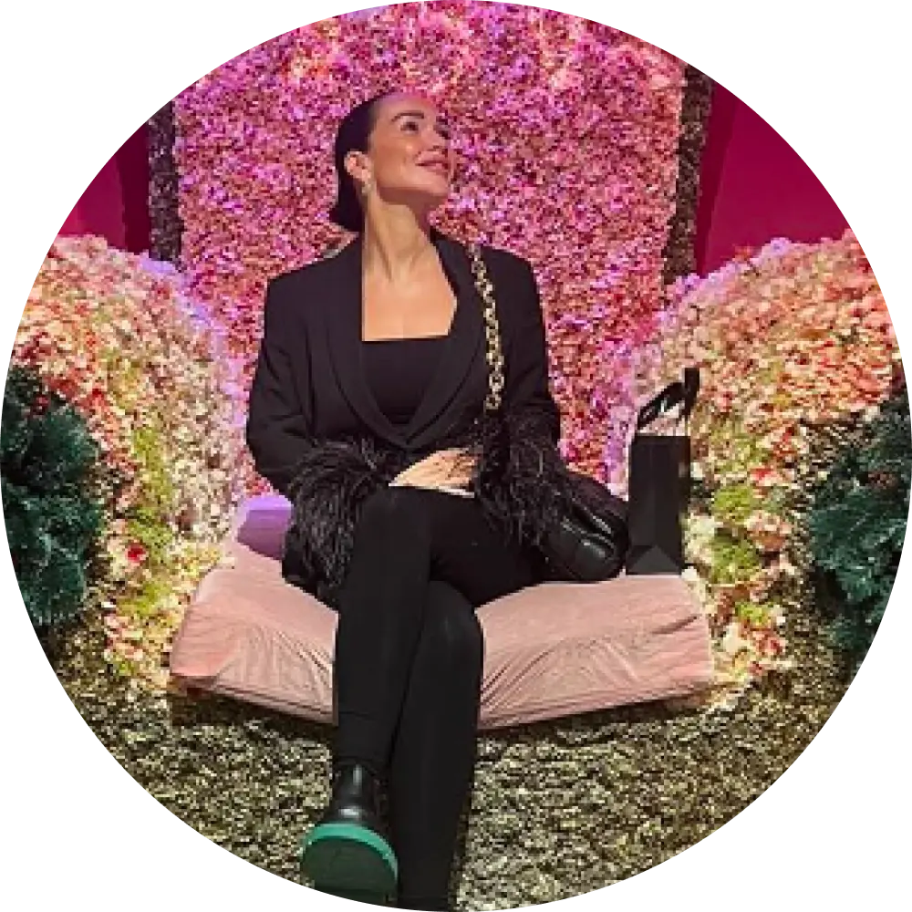 woman in a black outfit and boots sitting on trove big chair