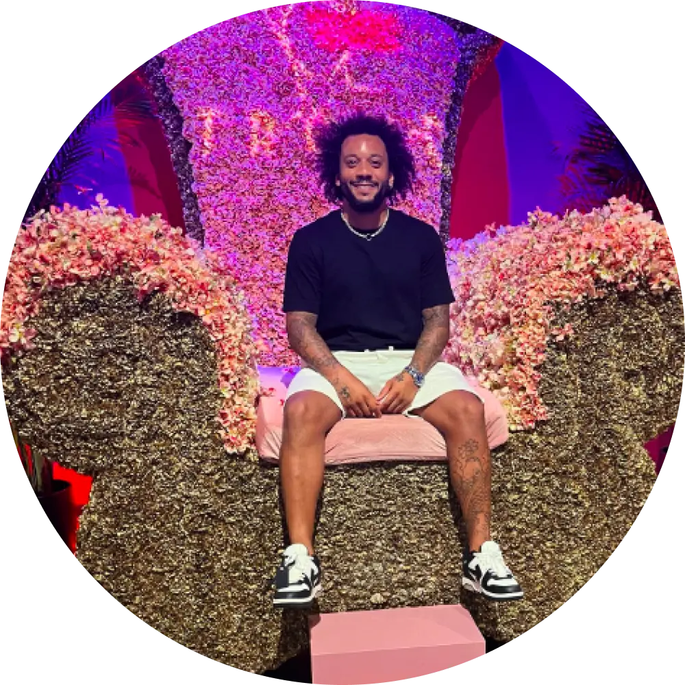 man in a black outfit and sneakers sitting on trove big chair in dubai
