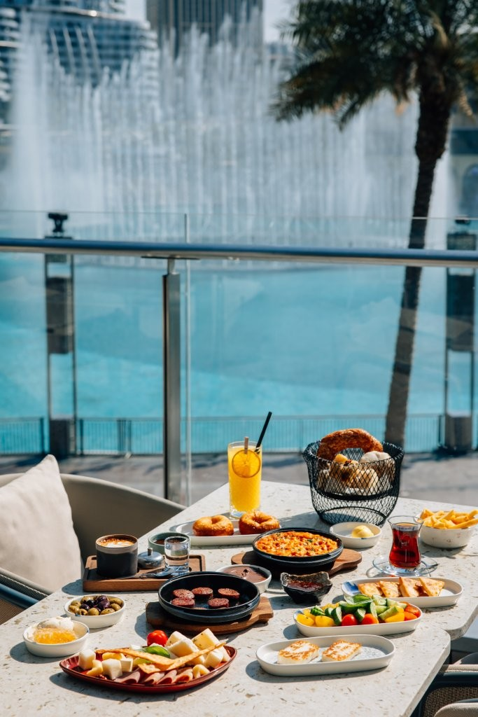 Food items on the table with a fountain in the back