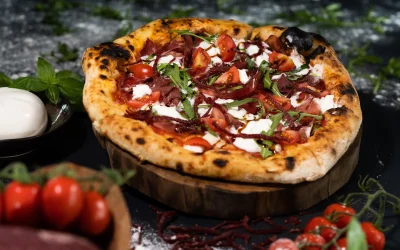 Pizza Margaritha on a table with cherry tomatoes